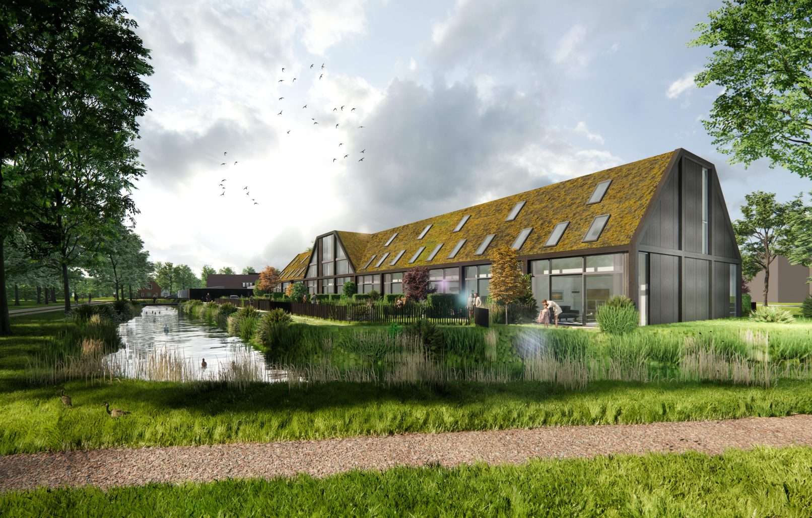 Een als langgerekte woonschuur ontworpen woongebouw met een sedum begroeide kap in een landelijke setting, aan het water.