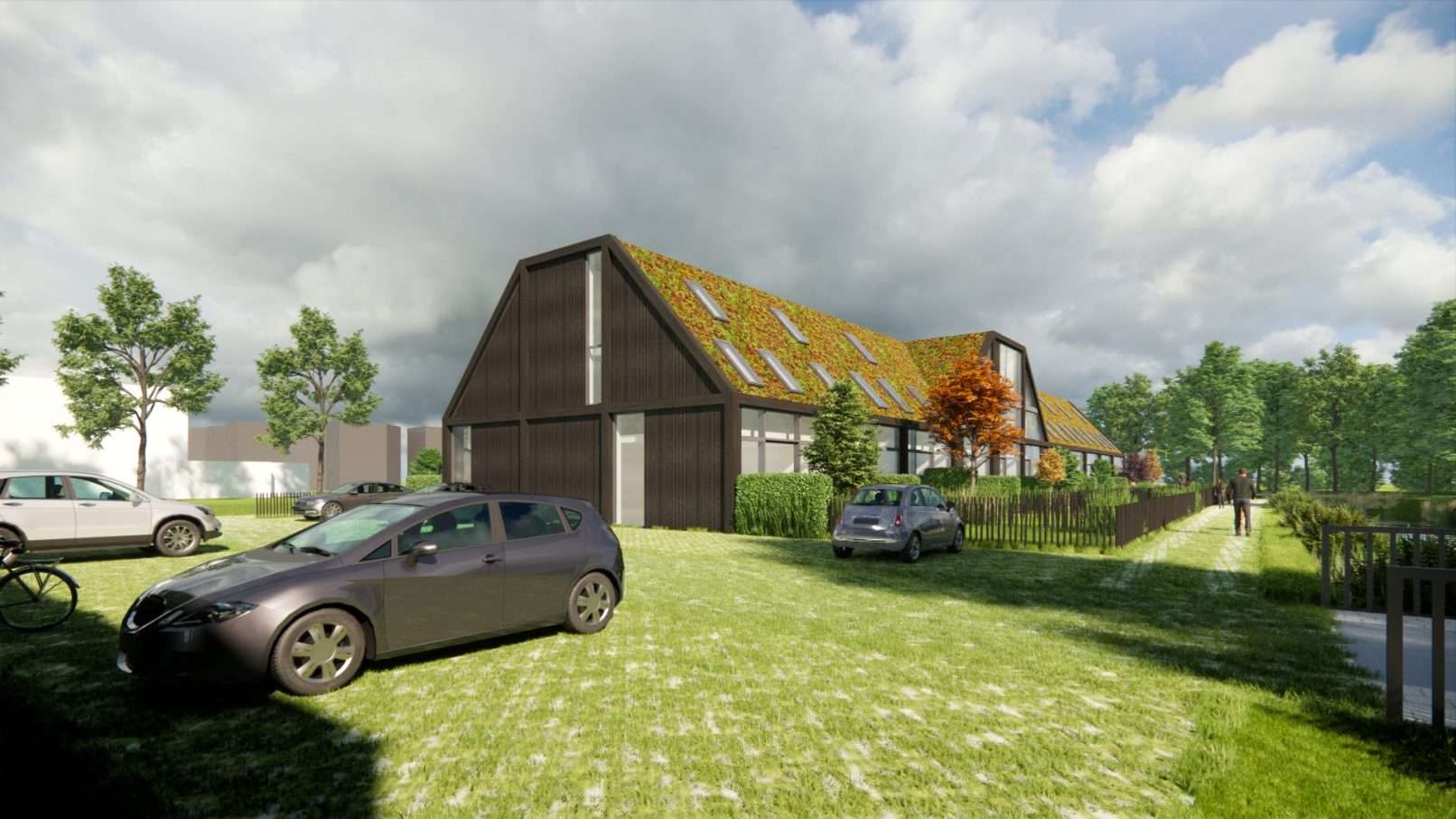 Een als langgerekte woonschuur ontworpen woongebouw met een sedum begroeide kap in een landelijke setting, aan het water.